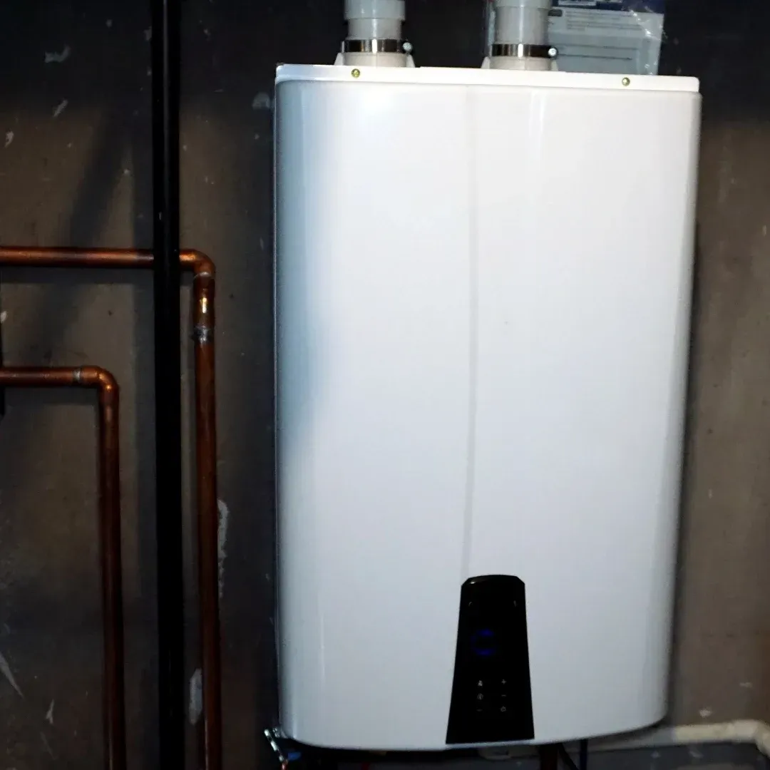 White wall-mounted boiler or water heater in a utility closet with copper pipes on the left.